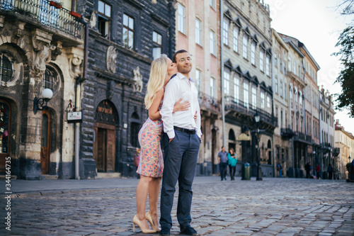 walking down the street together. Happy young man and smiling woman walking through the streets of Old Town, © ostap_davydiak