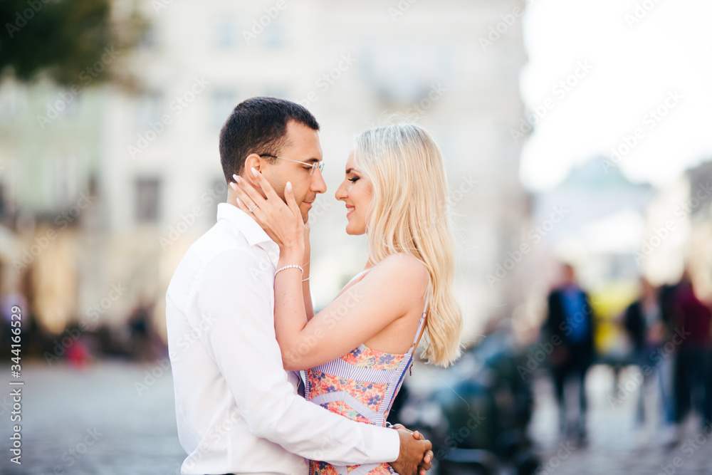 Fototapeta premium walking down the street together. Happy young man and smiling woman walking through the streets of Old Town,