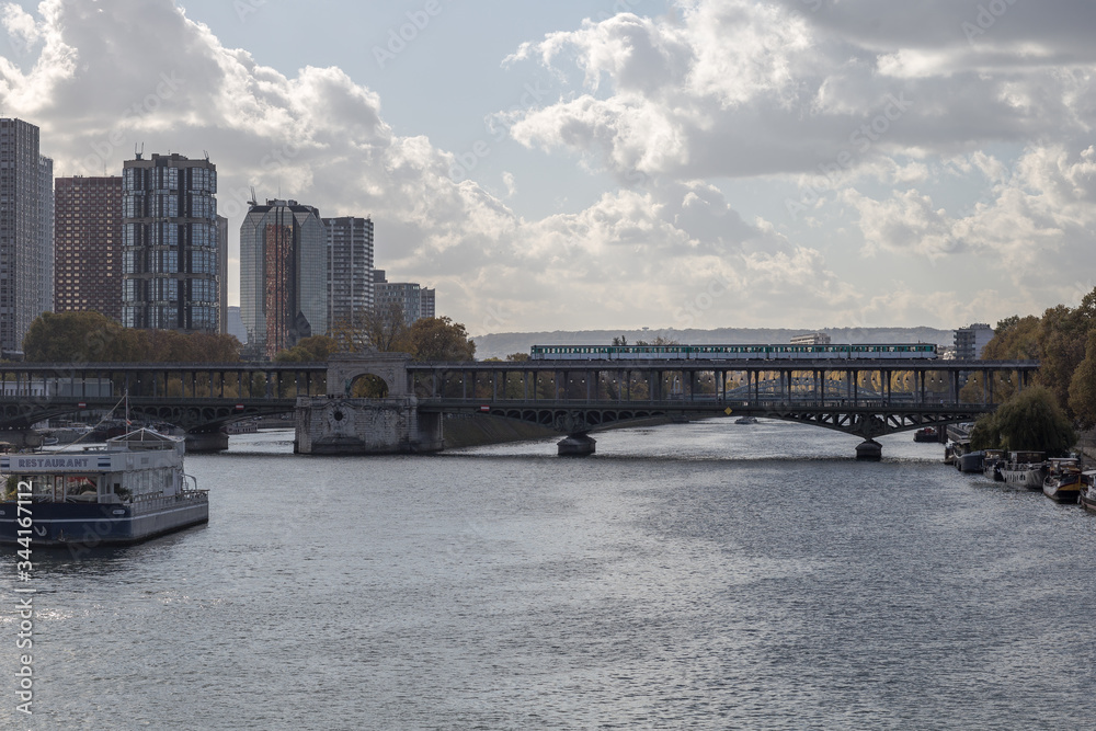 Subway train crossing over Seine river in urban Paris France on cloudy but sunny day Subway train crossing over Seine river in urban Paris France on cloudy but sunny day