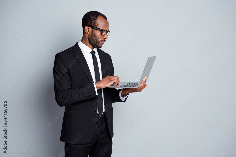 Portrait of his he nice attractive classy focused elegant imposing guy wearing suit using laptop writing e-mail letter correspondence isolated over grey pastel color background Portrait of his he nice attractive classy focused elegant imposing guy wearing suit using laptop writing e-mail letter correspondence isolated over grey pastel color background
