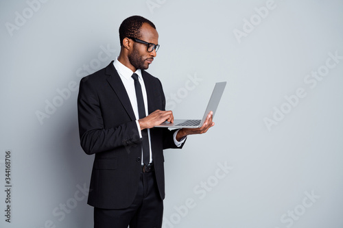 Portrait of his he nice attractive classy focused elegant imposing guy wearing suit using laptop writing e-mail letter correspondence isolated over grey pastel color background