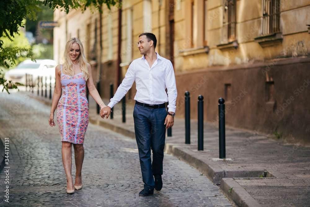 walking down the street together. Happy young man and smiling woman walking through the streets of Old Town,