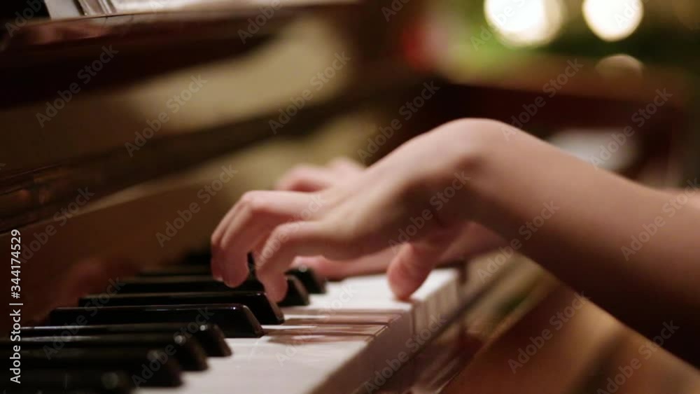Young girl playing piano at home education.