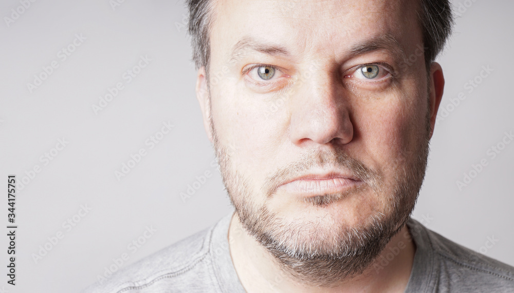 mid adult man looking at camera - close crop headshot with copy space on gray background mid adult man looking at camera - close crop headshot with copy space on gray background