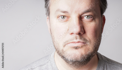 mid adult man looking at camera - close crop headshot with copy space on gray background