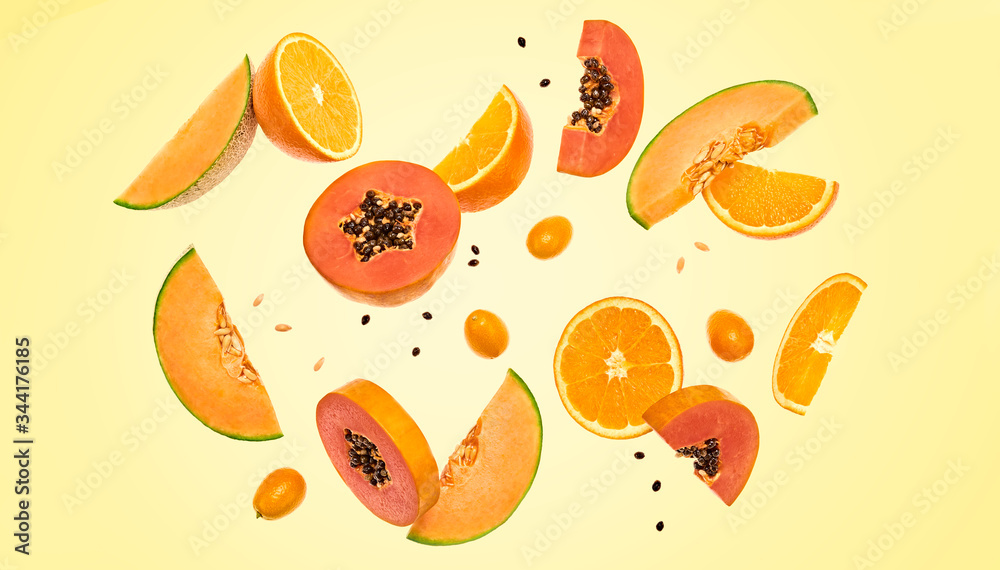 Flying fruits healthy summer background. Papaya, orange, melon. Levitation, falling fly fruit. Tropical creative concept. Colorful fruity summertime orange vivid design Flying fruits healthy summer background. Papaya, orange, melon. Levitation, falling fly fruit. Tropical creative concept. Colorful fruity summertime orange vivid design