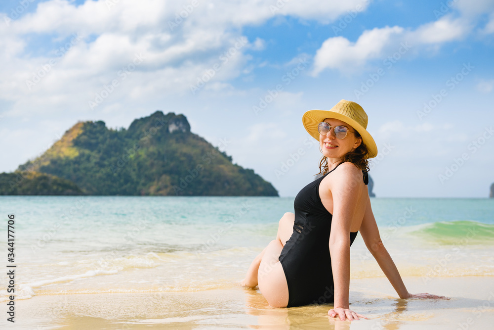 Smiling woman sit at paradise thai beach