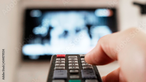 Male hand holding remote the control turn off smart tv. Close up.