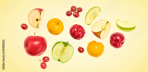 Flying Fruits healthy food summer color background. Apple  plum  grape. Colorful levitation  falling fly fruit creative vitamin concept. Colorful fruity summertime vivid design