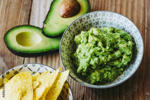 Guacamole fait maison avec des tortillas chips de maïs - Préparation traditionnel mexicaine épicée photo