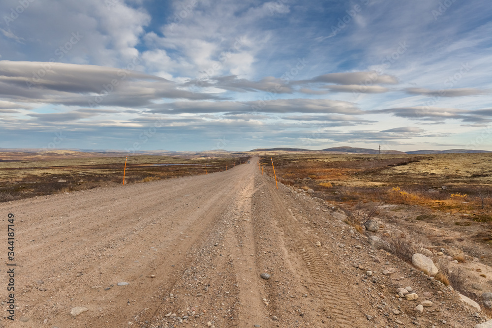 Gravel road to Teriberka in northern tundra landscape of Kola Peninsula. Natural scenery in autumn season. Murmansk Oblast, Russia Gravel road to Teriberka in northern tundra landscape of Kola Peninsula. Natural scenery in autumn season. Murmansk Oblast, Russia