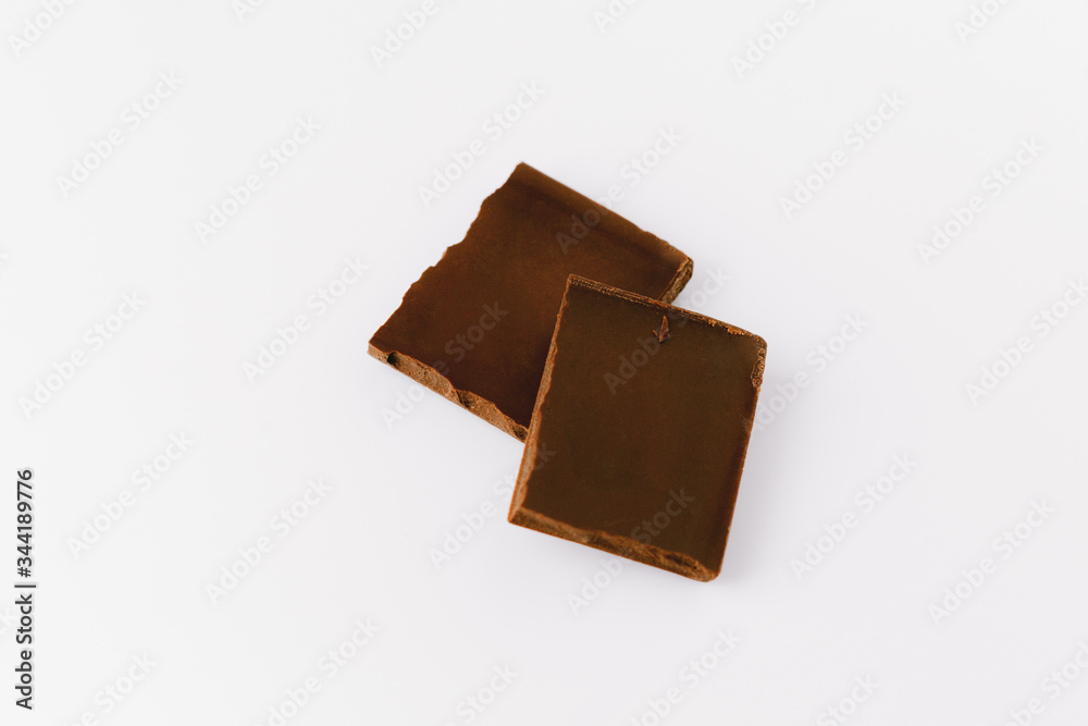 Macro photo of Chocolate bar. Broken pieces over white background Macro photo of Chocolate bar. Broken pieces over white background