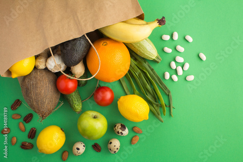 Fototapeta Naklejka Na Ścianę i Meble -  Paper bag of vegetables and fruits  on the green  background. Bag food concept. Top view.Copy space.