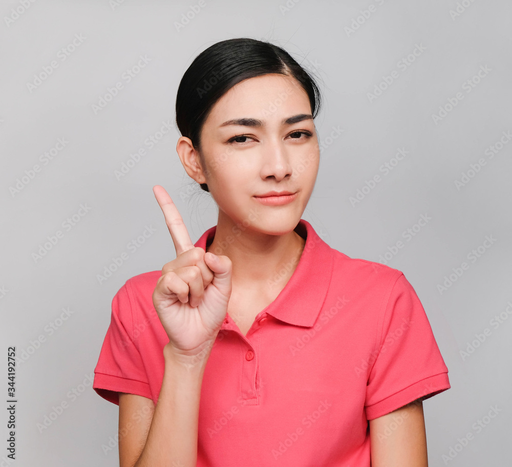 young beautiful asian woman wore pink t shirt, Showed Pointing and wondering expression , on gray background young beautiful asian woman wore pink t shirt, Showed Pointing and wondering expression , on gray background