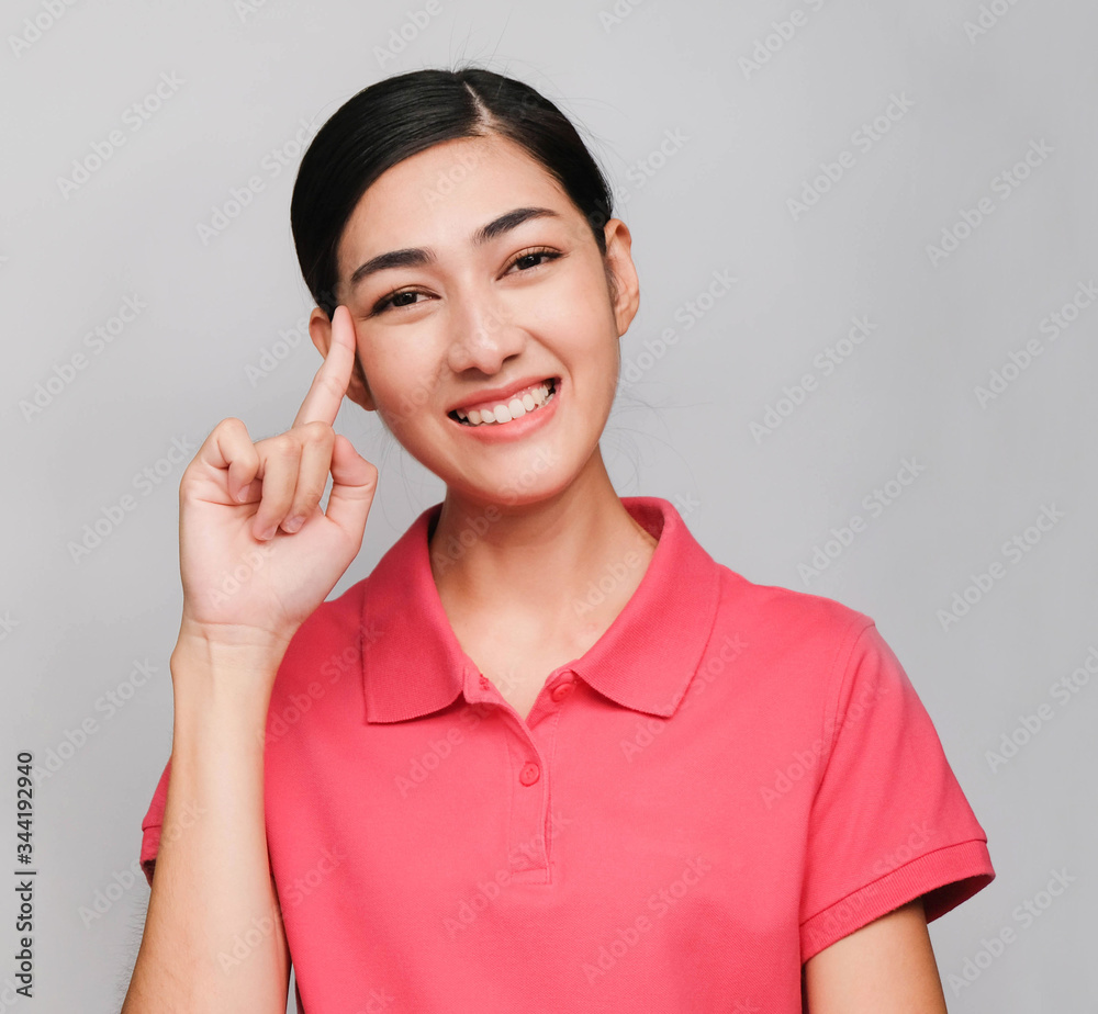 young beautiful asian woman wore pink t shirt, Showed Thinking expression ,smile on gray background young beautiful asian woman wore pink t shirt, Showed Thinking expression ,smile on gray background