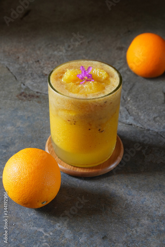 Fresh plum juice mixed with orange juice with mashed mango paste on concrete table. 