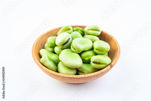 Fresh broad bean pods and broad beans on white background