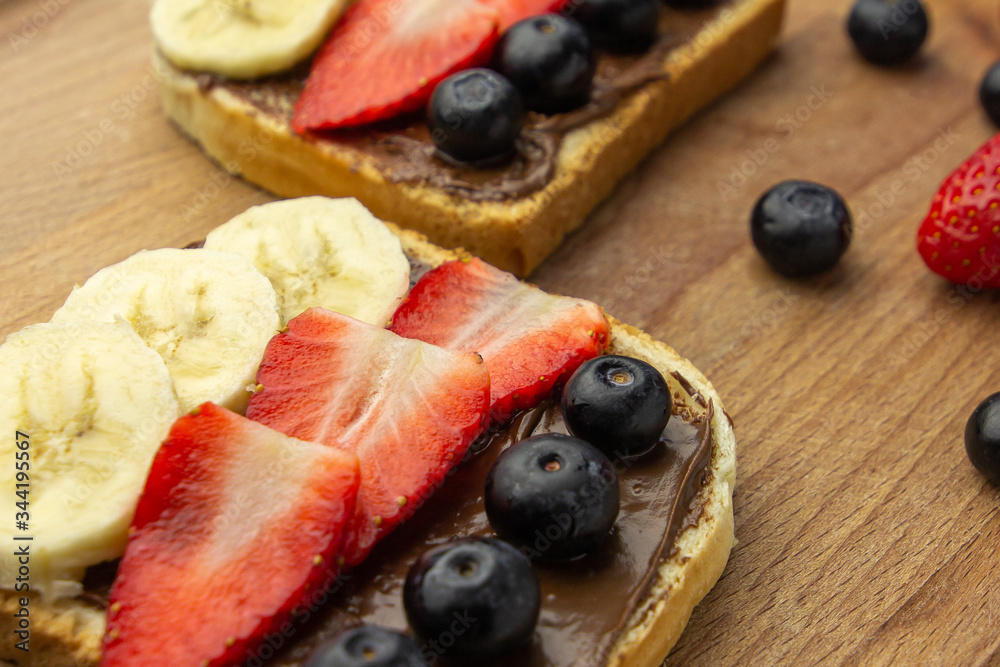 Tasty sandwiches with fruits on a wooden desk. Concept of healthy breakfast. Tasty sandwiches with fruits on a wooden desk. Concept of healthy breakfast.