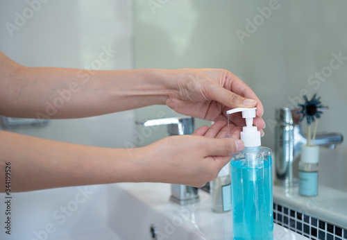 Asia people using alcohol gel for cleaning bacteria and virus protect infection and spread of COVID 19 , Woman hand press bottle alcohol gel.