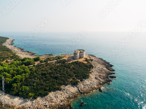 The ancient fort Arza at the entrance to the Bay of Kotor in Montenegro, in the Adriatic Sea, on the peninsula of Lustica. Fortress for military defense. Aerial photo from the drone. photo