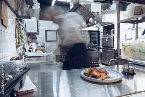 Behind the scenes of brands. The chef cooking in a professional kitchen of a restaurant meal for client or delivery. Open business from the inside. Meals during the quarantine. Hurrying up  motion.