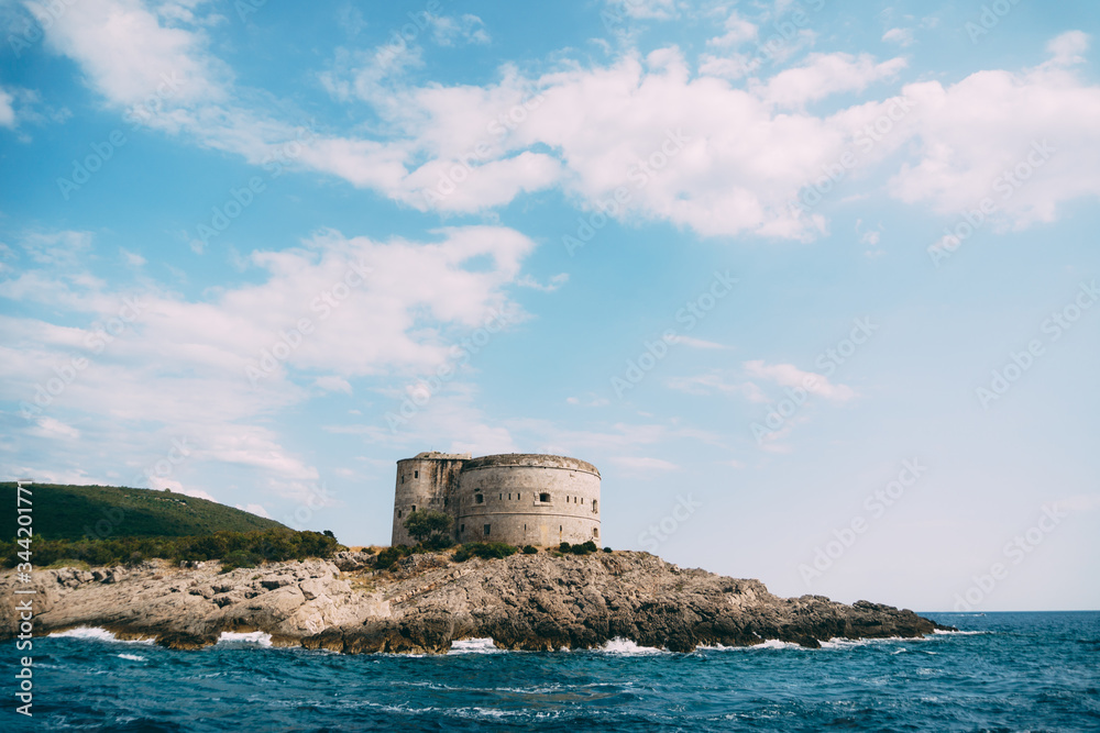 The ancient Austro-Hungarian fort Arza at the entrance to the Bay of Kotor in Montenegro, in the Adriatic Sea, on Lustica peninsula. Fortress for military defense. Stone tower built in 19th century.