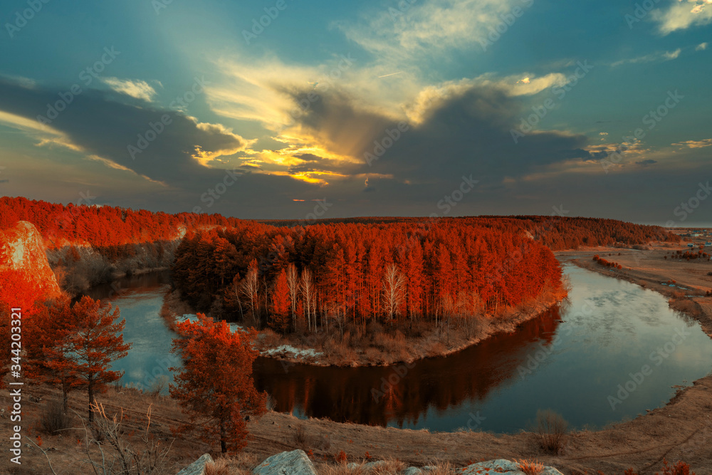 beautiful evening sunset. autumn landscape trees with red leaves. island in the middle of the river.