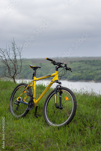 Yellow bicycle on green grass by the river © galilo3981