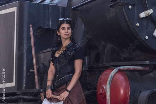 Beautiful girl in steampunk clothes on the background of the train