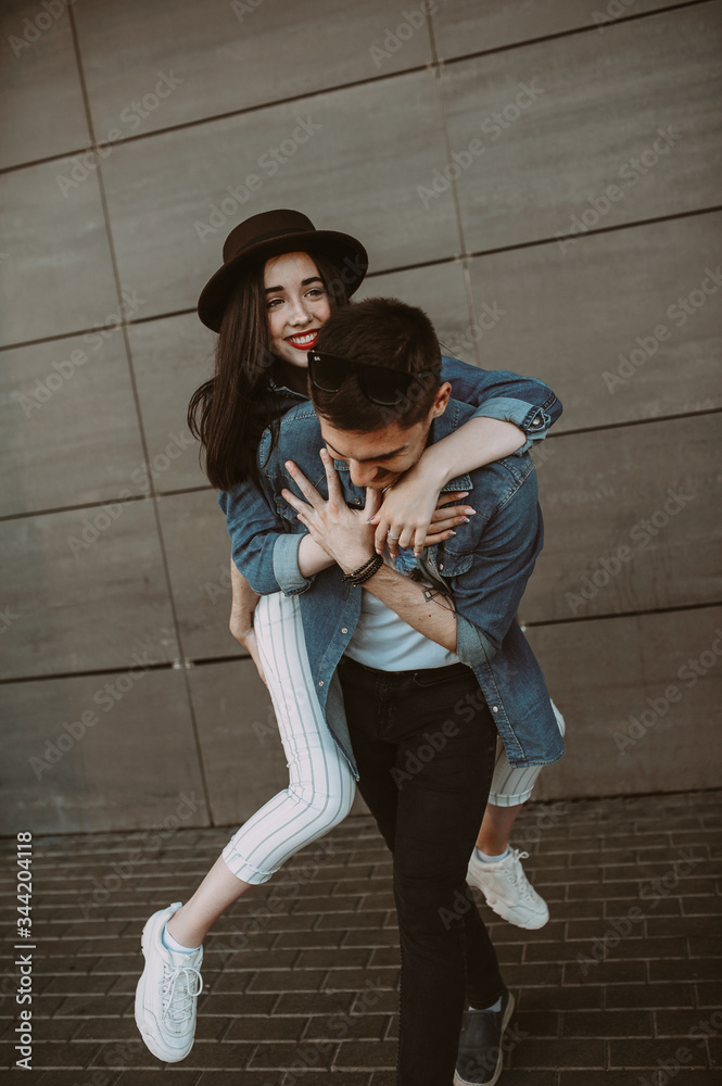 Beautiful and stylish guy and girl are having fun in the park. smiling and having fun