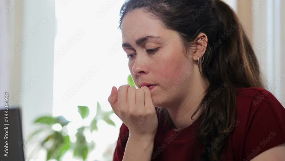The woman is nervous, biting her nails and typing on her laptop. Then she is very surprised and happy and continues to type. Concept of emotions, success and remote work The woman is nervous, biting her nails and typing on her laptop. Then she is very surprised and happy and continues to type. Concept of emotions, success and remote work