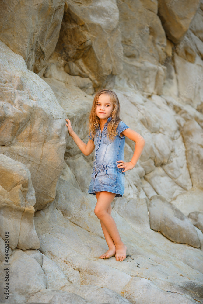 little girl standing on rock at sunset. travel.
