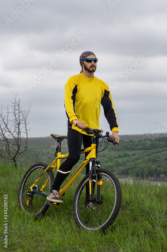 A cyclist sits on a bicycle and looks into the distance
