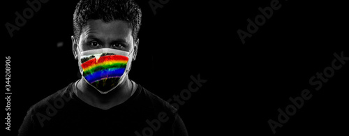 Man with rainbow mask on black background. Virus precaution concept. Together against Covid-19 © MR.PLAY