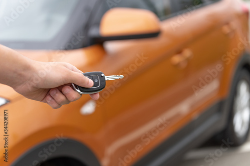 Man is opening his car with the control remote key. Close-up image of a hand with car key