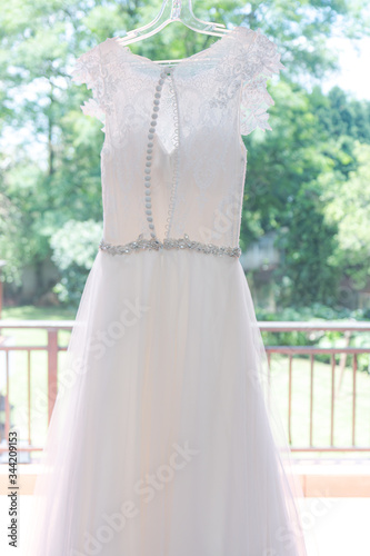 Back of a white wedding dress with a garden in the background 