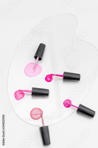 Pink nail polish palette with brushes isolated on white.
