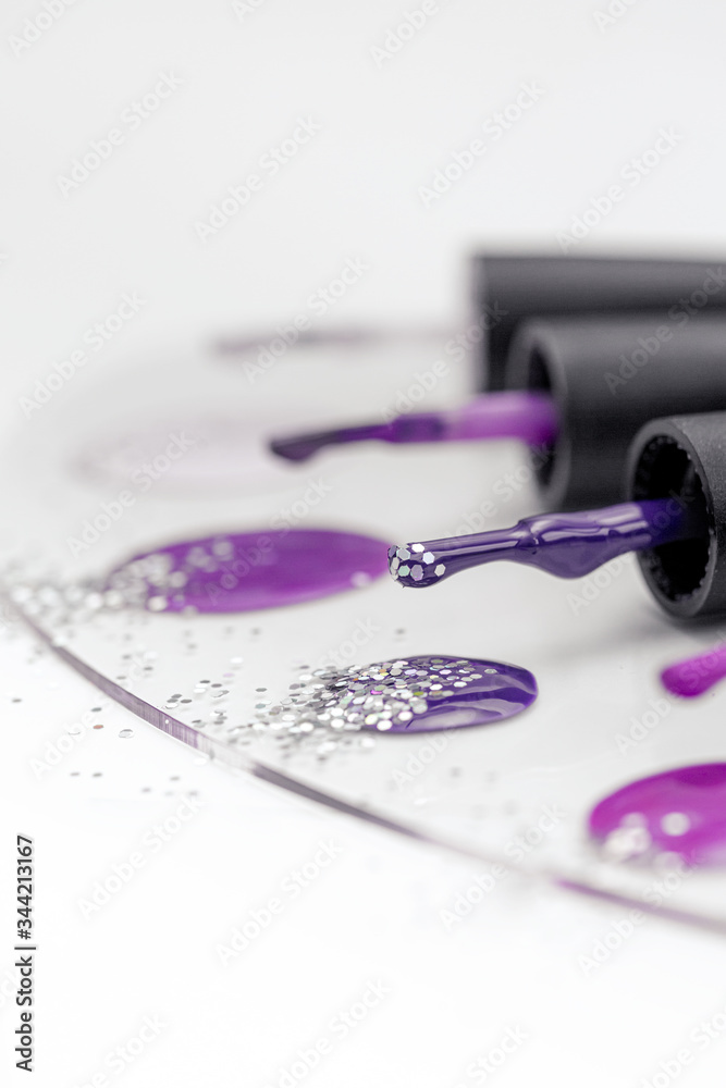 Purple nail polish palette with brushes and sparkles isolated on white. Purple nail polish palette with brushes and sparkles isolated on white.