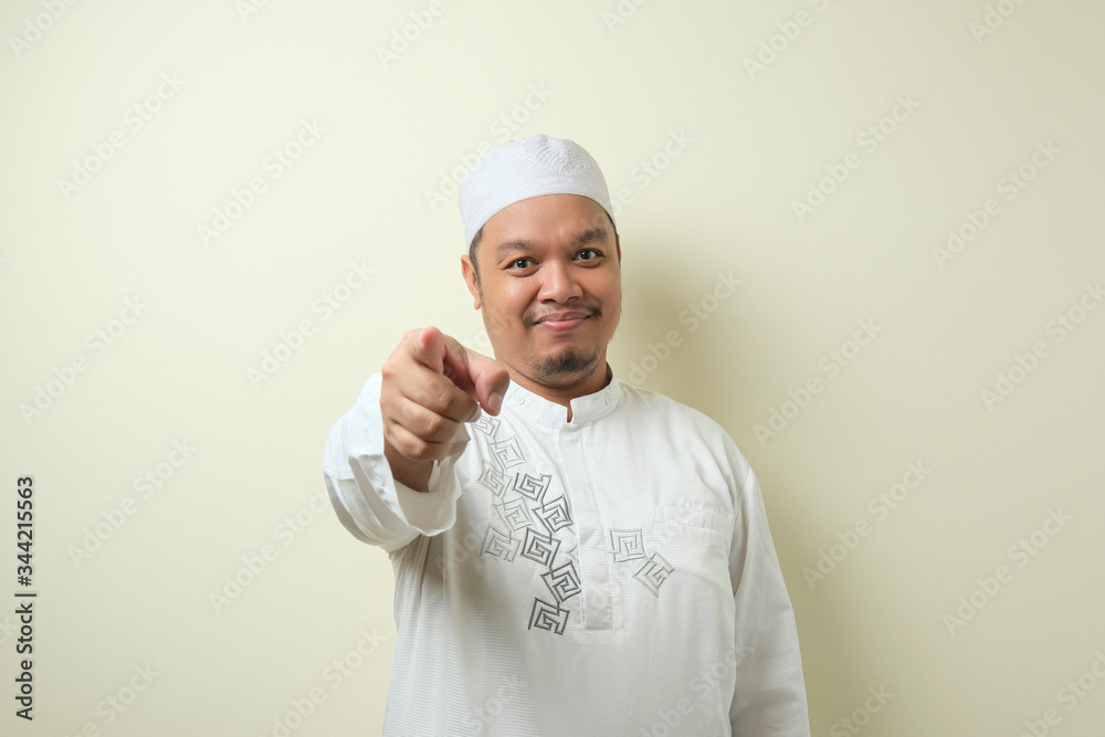 Portrait of young Asian muslim man pointing forward Portrait of young Asian muslim man pointing forward