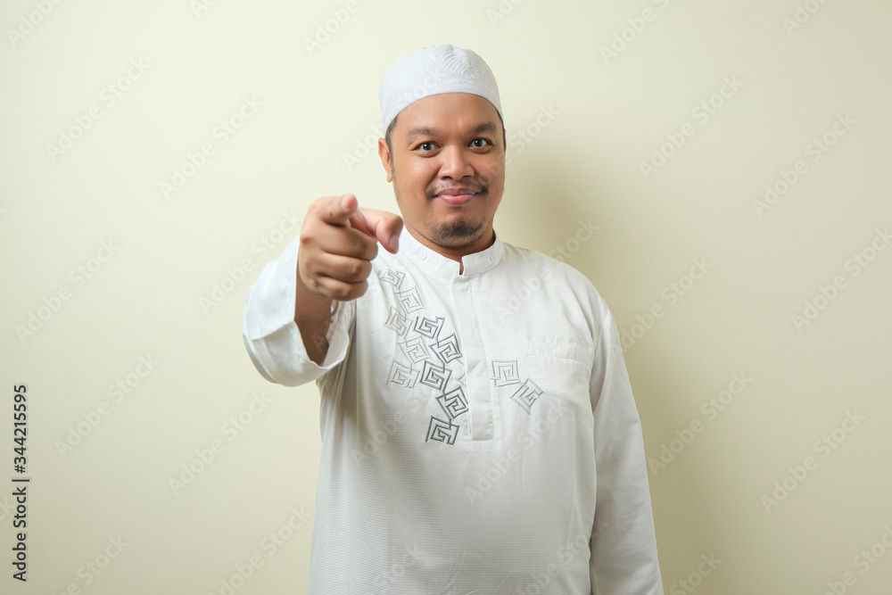 Portrait of young Asian muslim man pointing forward Portrait of young Asian muslim man pointing forward