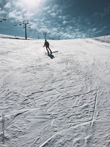 mountain top with snow, sky, clouds, ski-run and ski lift
