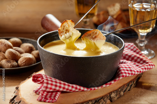 Steaming hot cheese fondue served with wine photo