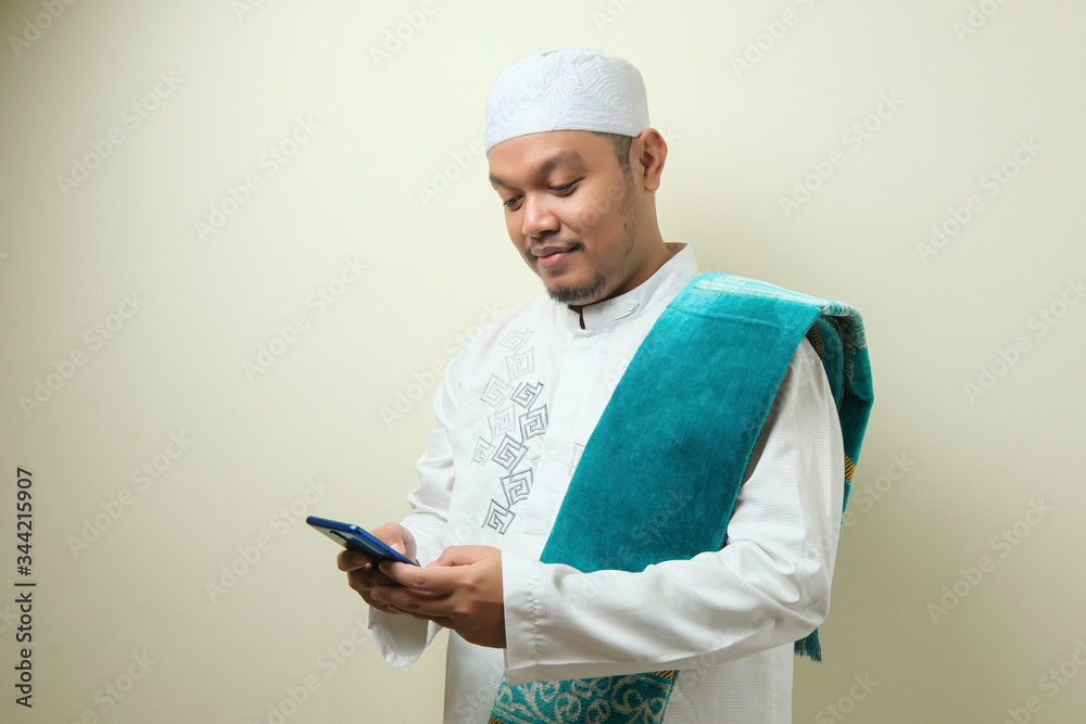 Fat Asian muslim man accessing his smart phone Fat Asian muslim man accessing his smart phone