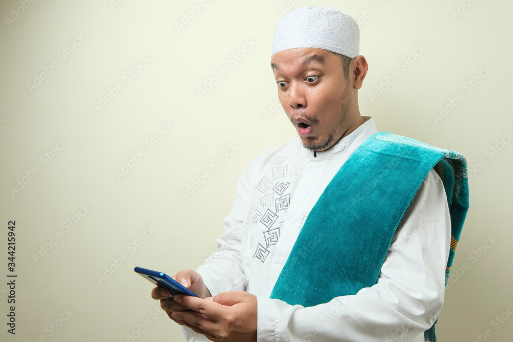 Fat Asian Muslim men looks surprised at the good news on phone Fat Asian Muslim men looks surprised at the good news on phone