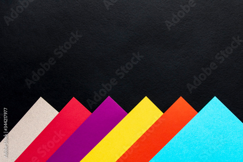 Multi-colored abstract geometric background. Colored sheets of paper on a black background. Trending colors 2020.