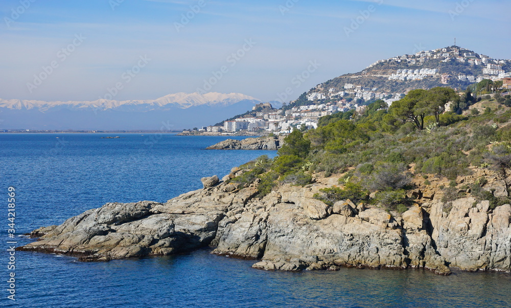 Spain Mediterranean sea coastline near Roses town on the Costa Brava with snow on the Pyrenees mountains in background, Girona province, Catalonia, Alt Emporda