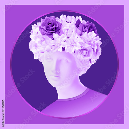 Beautiful young female violet face and colorful flowers. Plaster antique bust of Venus in a floral wreath. Beauty spring and summer model girl with fresh bouquet. © Ded Pixto