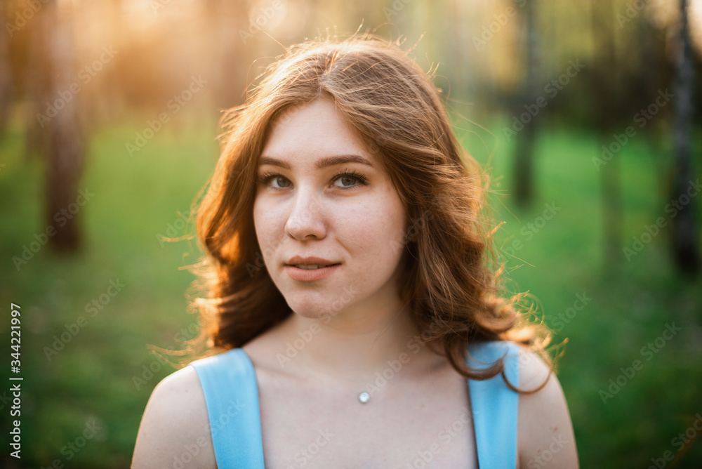 Beautiful young girl in a blue dress in a spring park