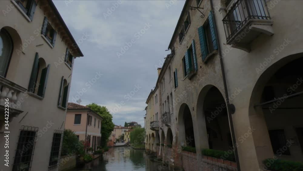 PAN SLOW MOTION - The Buranelli Canal is named after the merchants from Burano who lived along this watercourse in the 1500s. Cityscape with old houses on the canale, Treviso, Italy. PAN SLOW MOTION - The Buranelli Canal is named after the merchants from Burano who lived along this watercourse in the 1500s. Cityscape with old houses on the canale, Treviso, Italy.