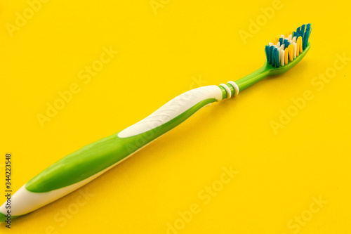 Clean toothbrush on a yellow background side view. Toothbrush close-up. Selective focus